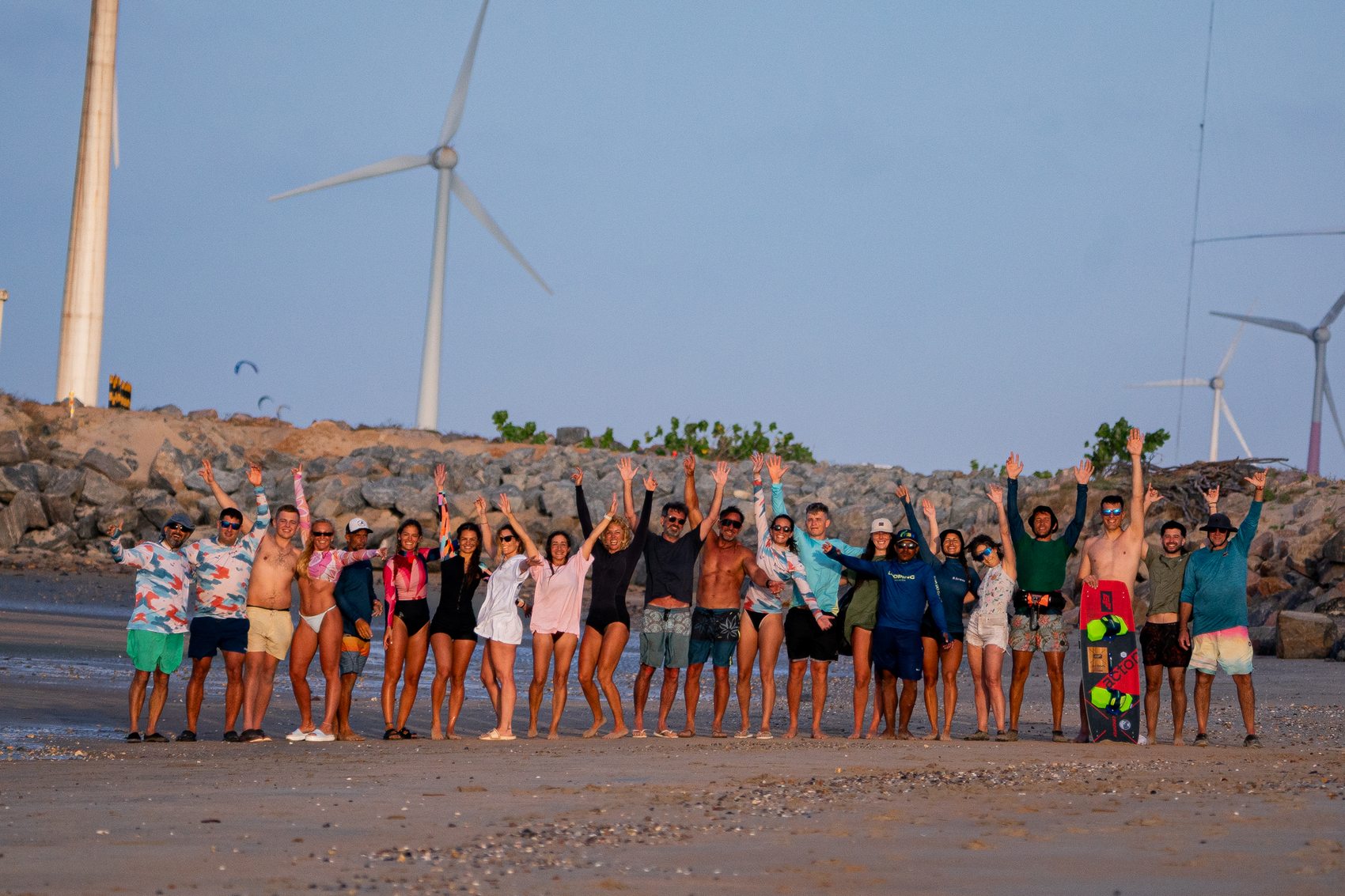 El grupo entero en la playa, con los brazos arriba